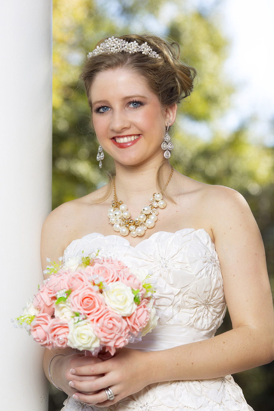 bridge posing in white wedding dress with flowers in hand